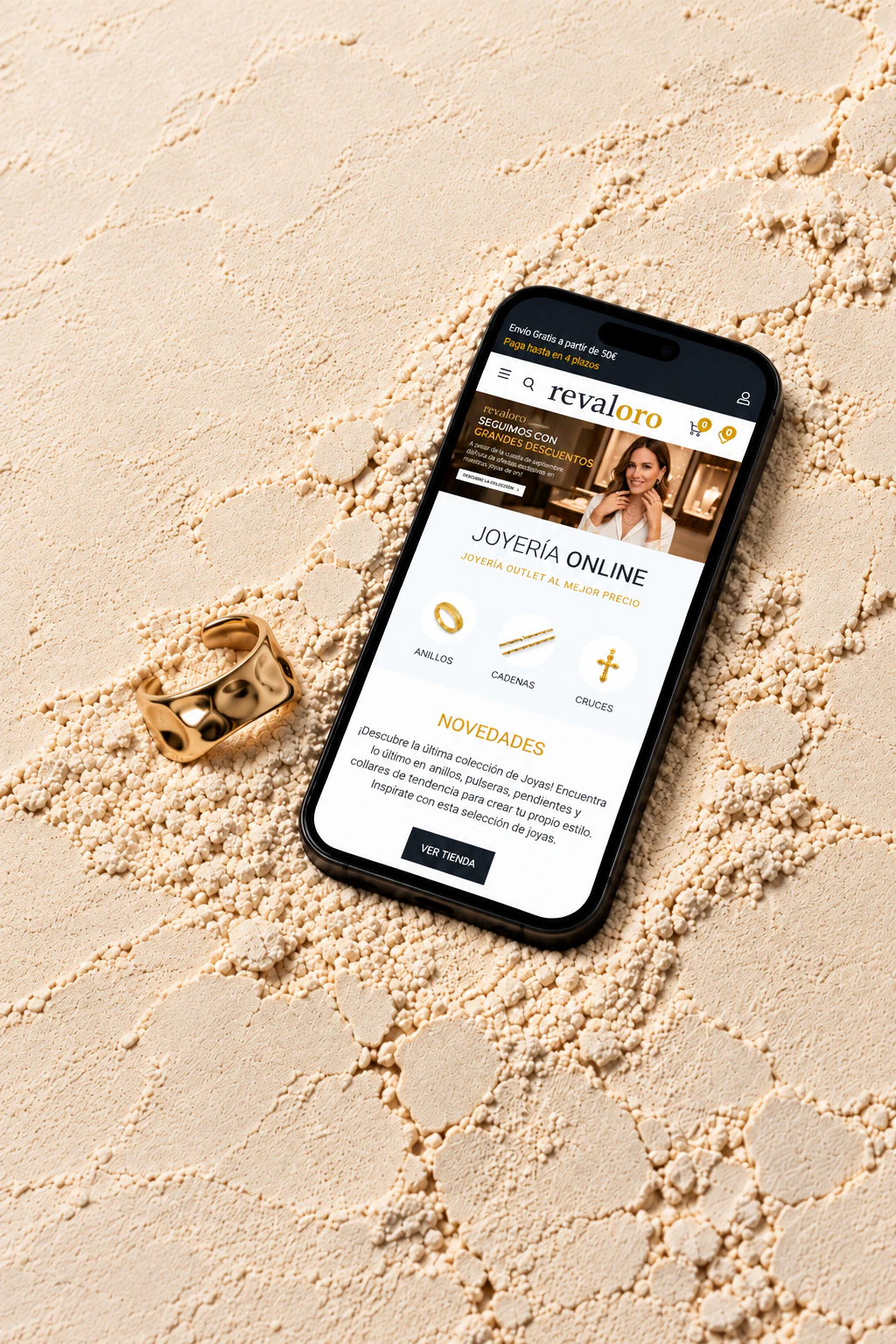 Proyecto ecommerce de Revaloro mostrado en un móvil sobre arena fina